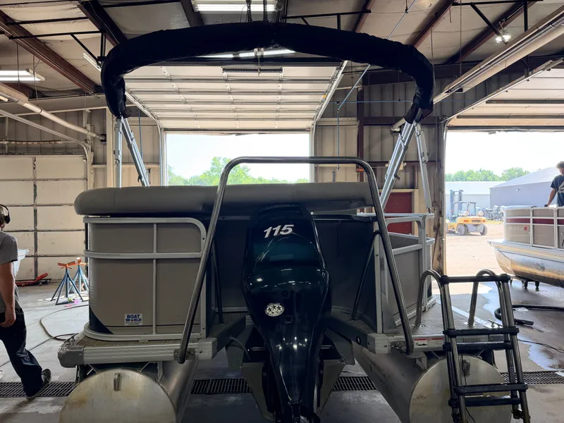 Slide: The Image of A 2007 Premier 210 Legend pontoon boat in a warehouse. It features a 115 HP engine. - 41