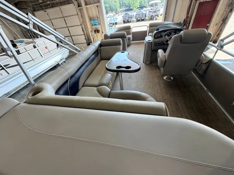 Slide: The Image of Interior of a 2007 Premier 210 Legend pontoon boat with beige seating and a table. - 7