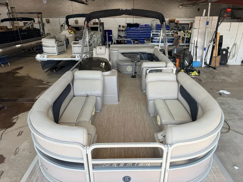 Slide: The Image of 2007 Premier 210 Legend pontoon boat with spacious seating area in a workshop. - 9