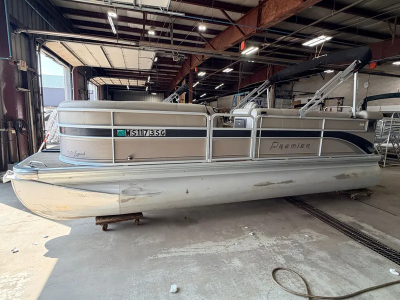 Slide: The Image of A silver pontoon boat, Premier 210 Legend, 2007 model, is parked in a warehouse. - 38