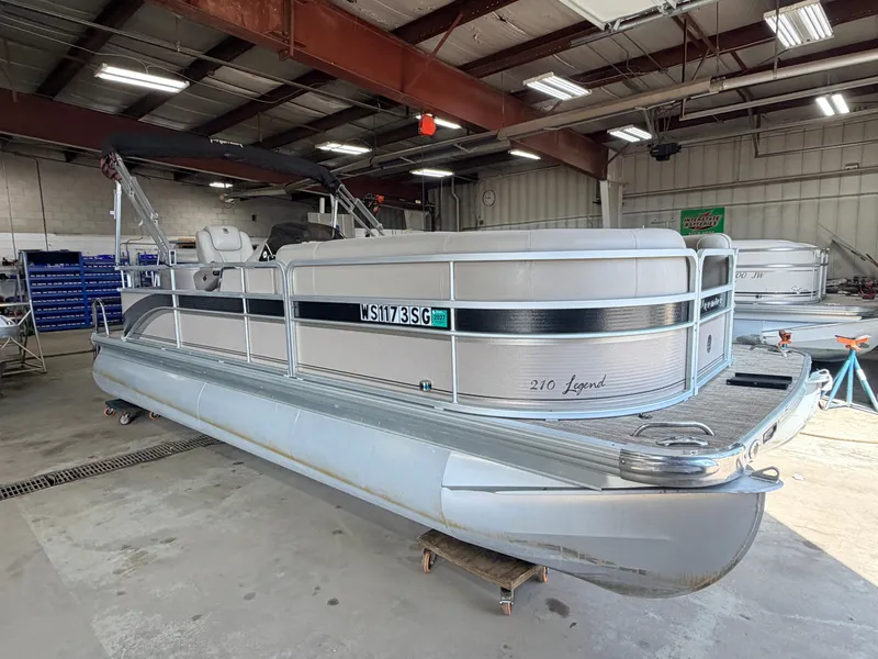 Slide: The Image of A 2007 Premier 210 Legend pontoon boat is in a warehouse. It features a silver railing. - 46