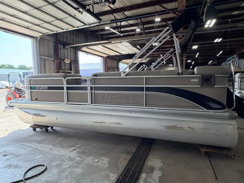 Slide: The Image of A 2007 Premier 210 Legend pontoon boat is in a warehouse. It features a gray railing. - 39