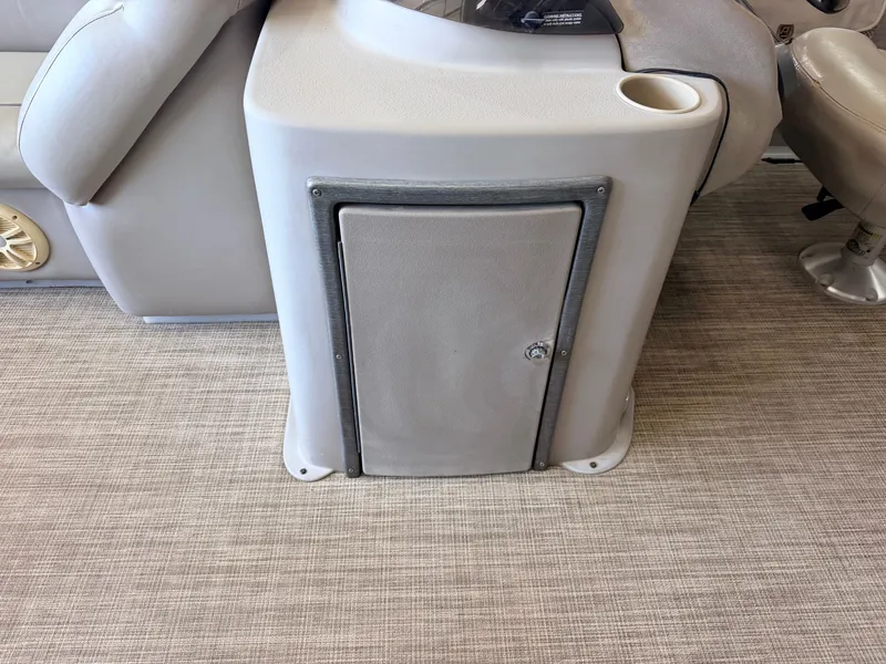 Slide: The Image of A gray storage compartment with a door and cup holder on a boat. - 17