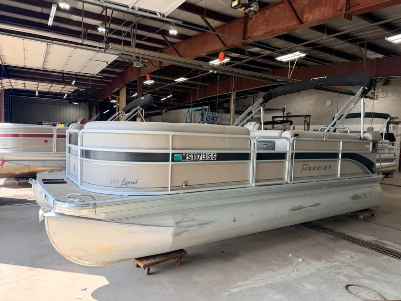 Slide: The Image of A 2007 Premier 210 Legend pontoon boat is in a warehouse. It features a sleek design. - 37