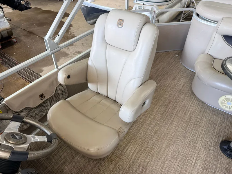 Slide: The Image of A beige leather seat on a 2007 Premier 210 Legend boat, with steering wheel and carpeted floor. - 20