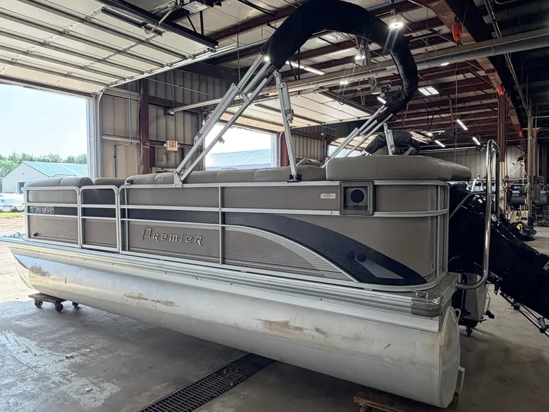 Slide: The Image of A gray pontoon boat by Premier, model 210 Legend, year 2007, is in a warehouse. - 40