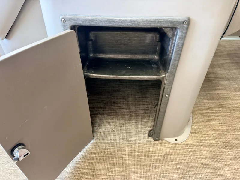 Slide: The Image of An open storage compartment with a door and two shelves on a boat. - 18