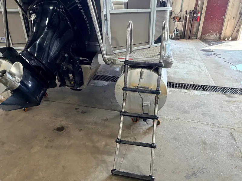 Slide: The Image of A 2007 Premier 210 Legend with a ladder at the stern and an outboard motor. - 34