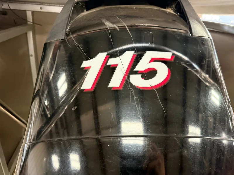 Slide: The Image of Close-up of a black outboard motor with the number 115 in red and white. - 48