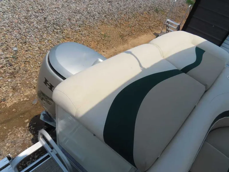 Slide: The Image of A 1999 Bennington Pontoon boat with beige and green seating and an outboard motor. - 21