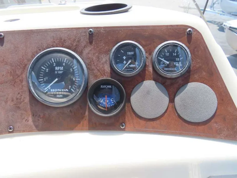 Slide: The Image of The image shows the dashboard of a 1999 Bennington Pontoon boat with various gauges. - 16