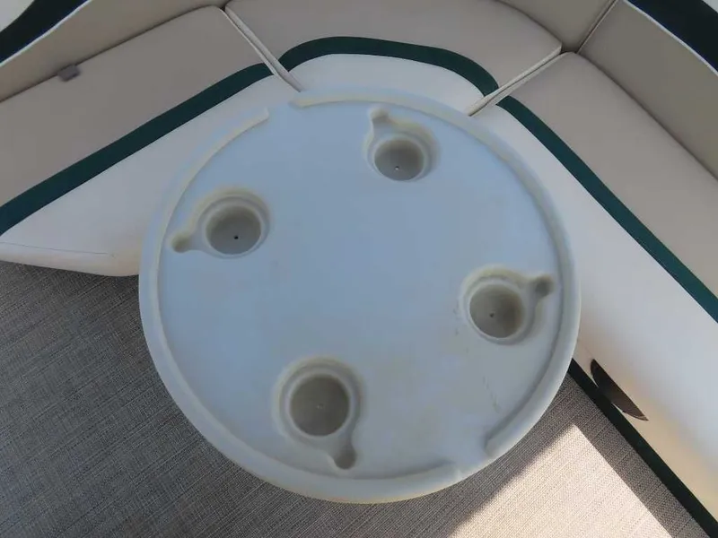 Slide: The Image of A round table with four cup holders on a 1999 Bennington Pontoon boat. - 19