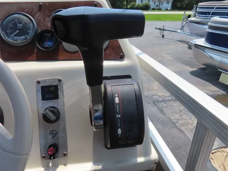 Slide: The Image of Close-up of a 1999 Bennington Pontoon throttle lever, with dashboard and gauges visible. - 18