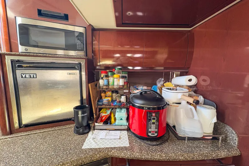 Slide: The Image of Galley kitchen in 2008 Sea Ray 380 Sundancer with microwave, mini fridge, and cooking essentials. - 78