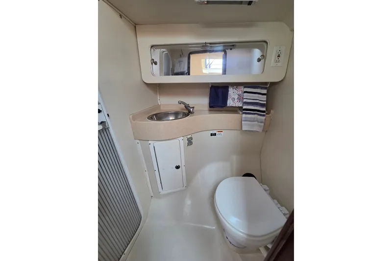 Slide: The Image of Compact bathroom in a 2002 Catalina 390 yacht with sink, mirror, and toilet. - 38