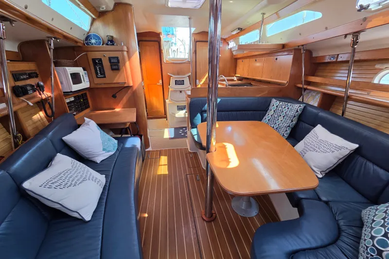 Slide: The Image of Luxurious interior of a 2002 Catalina 390 sailboat with cozy seating and wooden finishes. - 32