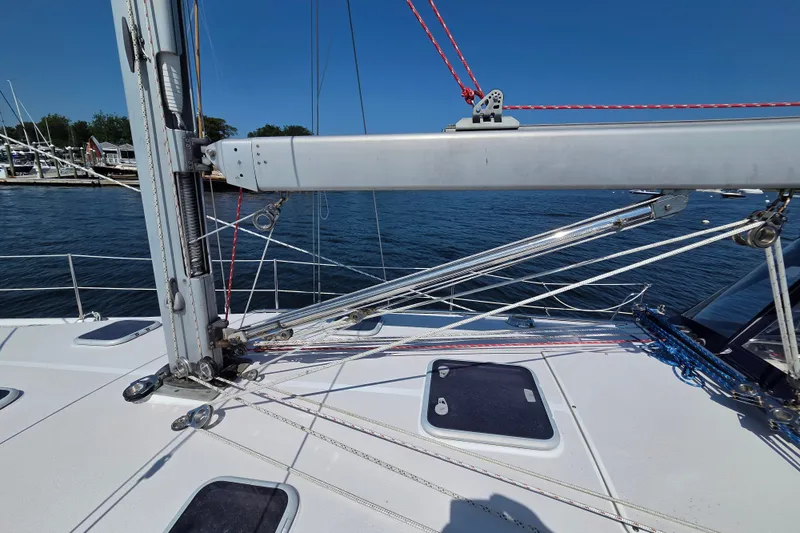 Slide: The Image of 2002 Catalina 390 sailboat deck with rigging and mast, docked by the water. - 27