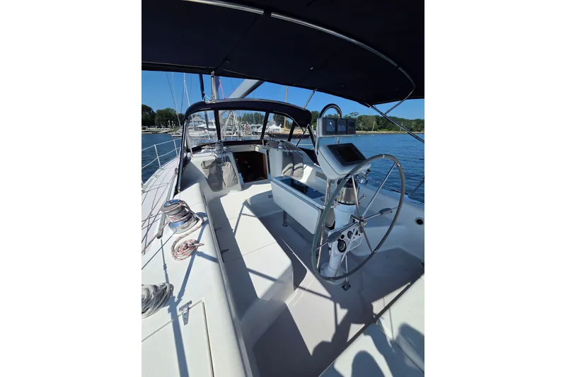 Slide: The Image of 2002 Catalina 390 sailboat cockpit with steering wheel, navigation equipment, and shaded seating area. - 14