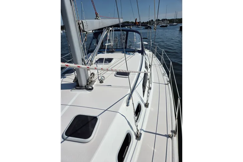 Slide: The Image of 2002 Catalina 390 sailboat deck view, moored in a marina with calm waters. - 23