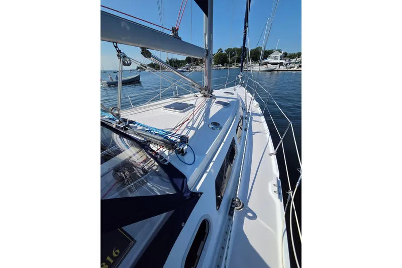 Slide: The Image of 2002 Catalina 390 sailboat docked in a serene marina setting. - 19