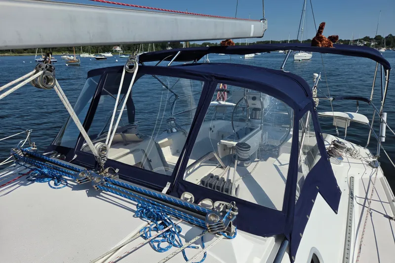 Slide: The Image of Catalina 390 sailboat from 2002, featuring a blue canopy and rigging, docked in a marina. - 25