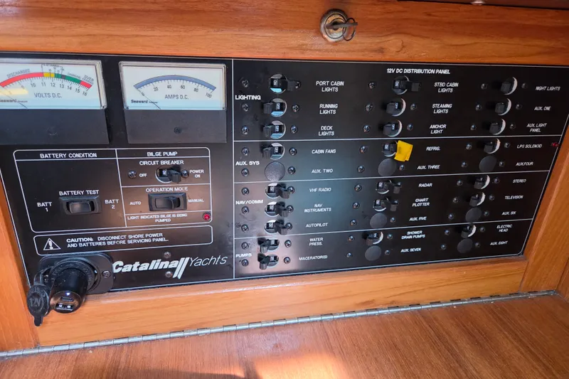 Slide: The Image of Control panel of a 2002 Catalina 390 yacht with various switches and gauges. - 41