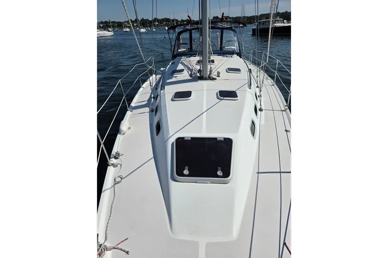 Slide: The Image of 2002 Catalina 390 sailboat deck view, moored in a serene harbor setting. - 22