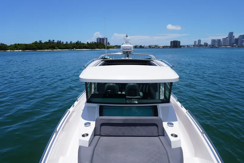 Slide: The Image of 2020 Axopar 37 XC Cross Cabin on calm waters with city skyline in background. - 18