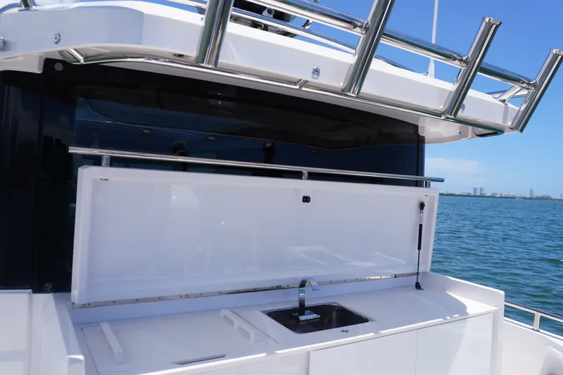 Slide: The Image of 2020 Axopar 37 XC Cross Cabin boat with outdoor sink and storage, overlooking the ocean. - 20