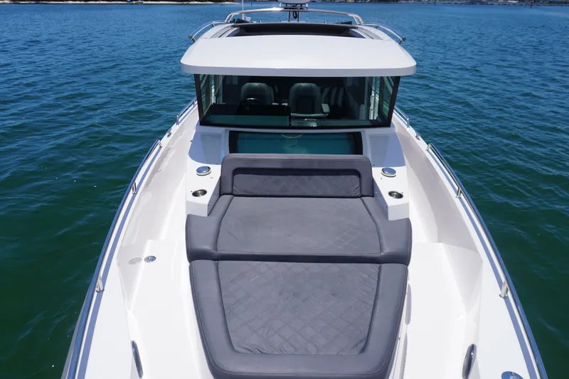 Slide: The Image of 2020 Axopar 37 XC Cross Cabin boat with sunbed on calm water. - 19
