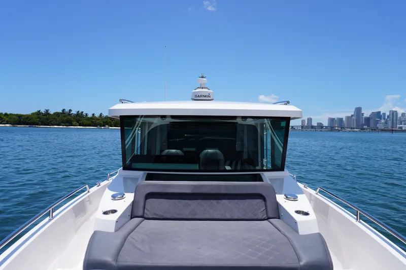 Slide: The Image of 2020 Axopar 37 XC Cross Cabin boat on water with city skyline in background. - 17