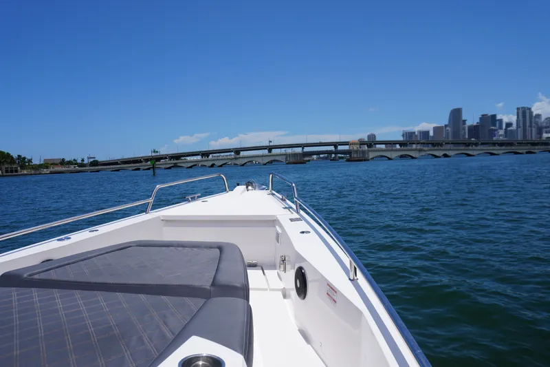 Slide: The Image of Axopar 37 XC Cross Cabin 2020 cruising near a city skyline and bridge. - 15
