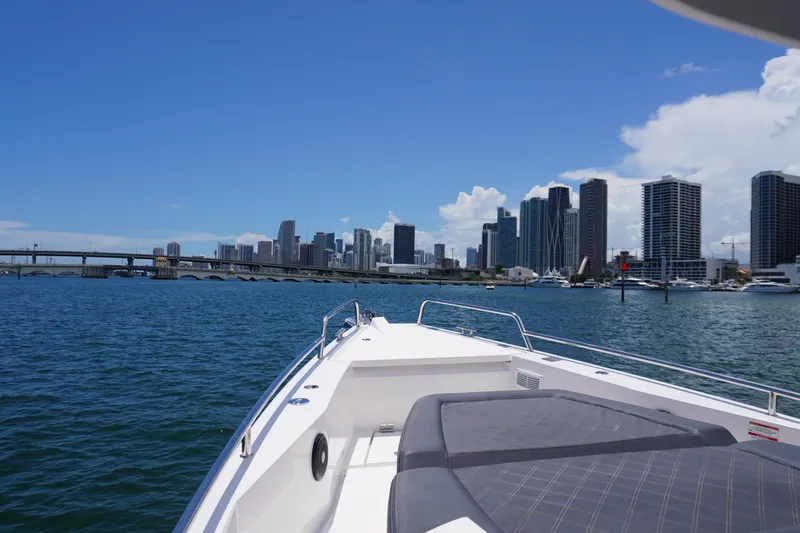 Slide: The Image of Axopar 37 XC Cross Cabin 2020 cruising near city skyline and bridge on a sunny day. - 14