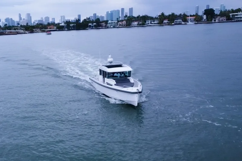 Slide: The Image of 2020 Axopar 37 XC Cross Cabin cruising near city skyline on calm waters. - 27
