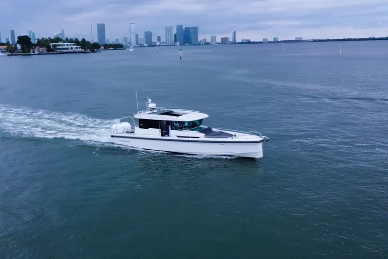 Slide: The Image of 2020 Axopar 37 XC Cross Cabin cruising near city skyline on calm waters. - 28
