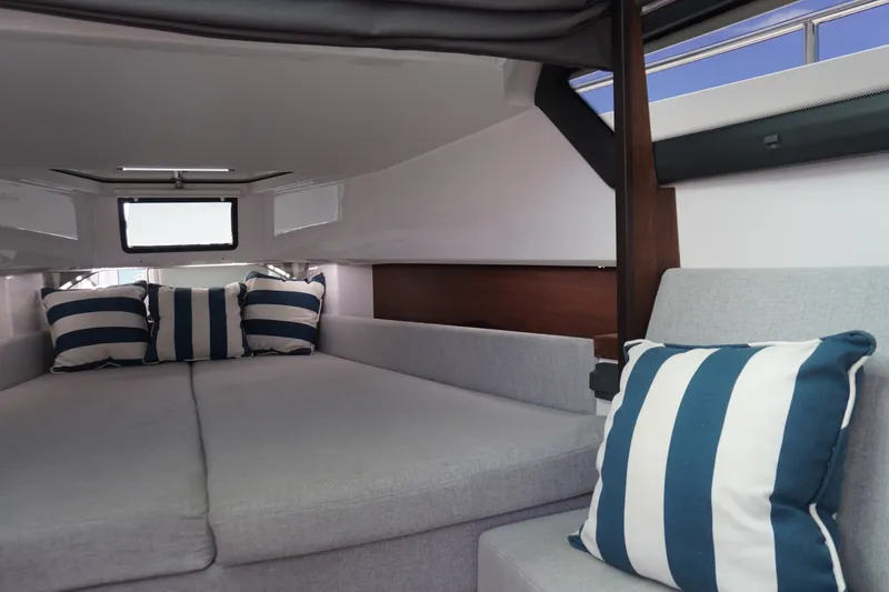 Slide: The Image of Interior of 2020 Axopar 37 XC Cross Cabin with striped cushions and cozy seating. - 24