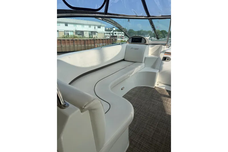 Slide: The Image of 2008 Cruisers Yachts 520 Express interior with white seating and waterfront view. - 32