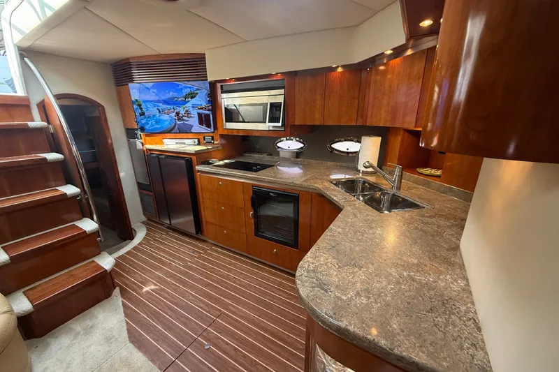 Slide: The Image of Luxurious 2008 Cruisers Yachts 520 Express interior with modern kitchen and elegant wood finishes. - 18
