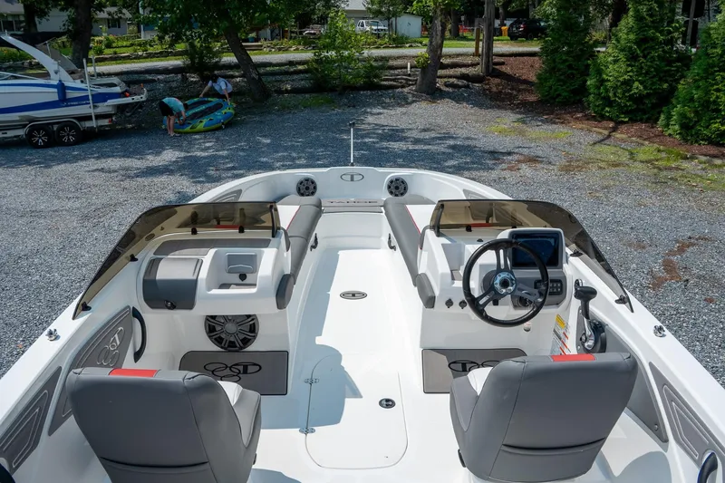 Slide: The Image of 2024 Tahoe T21 boat interior with modern steering and seating, parked outdoors. - 1