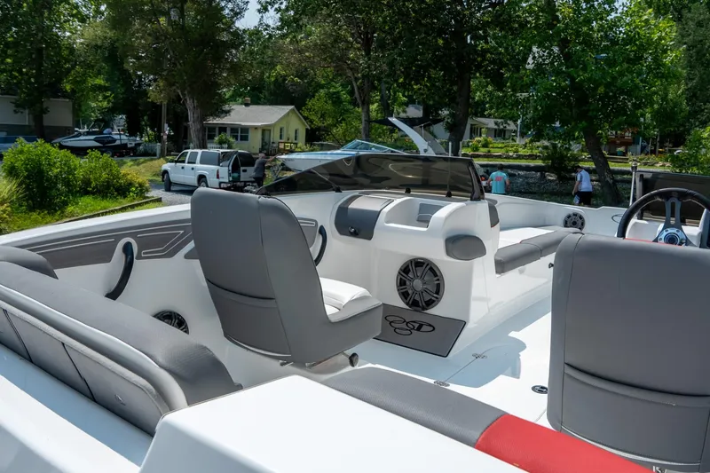 Slide: The Image of 2024 Tahoe T21 boat interior with modern seating and dashboard, surrounded by lush greenery. - 5
