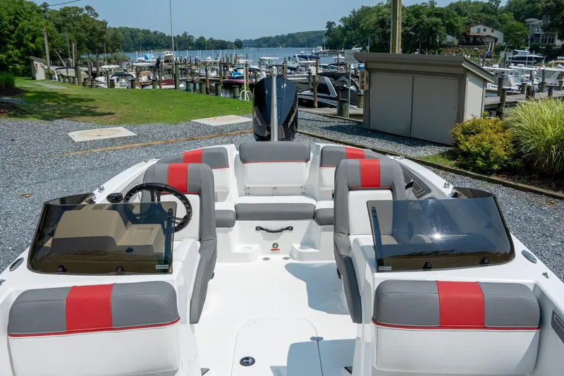 Slide: The Image of 2024 Tahoe T21 boat with red and gray seating, docked near a marina. - 3