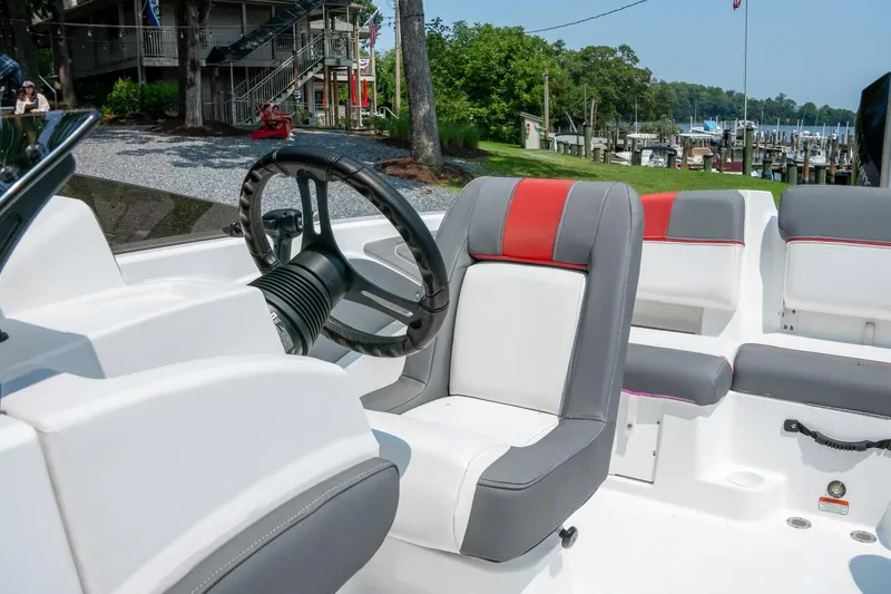 Slide: The Image of 2024 Tahoe T21 boat interior with steering wheel and cushioned seating. - 12