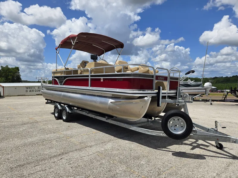Slide: The Image of A 2020 Lowe SF 232 pontoon boat on a trailer under a cloudy sky. - 9