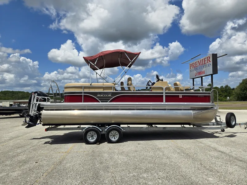 Slide: The Image of A 2020 Lowe SF 232 pontoon boat on a trailer under a cloudy sky. - 8