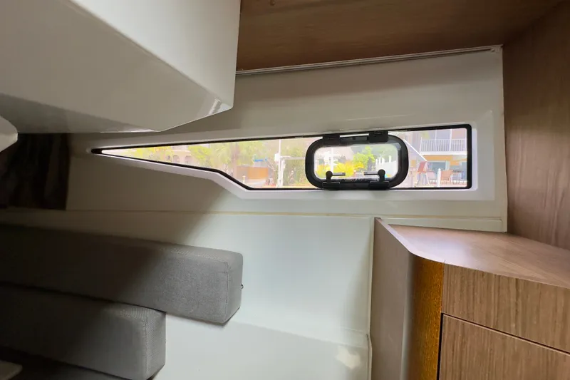 Slide: The Image of Interior view of 2018 Jeanneau NC 895 boat cabin with window and seating. - 31