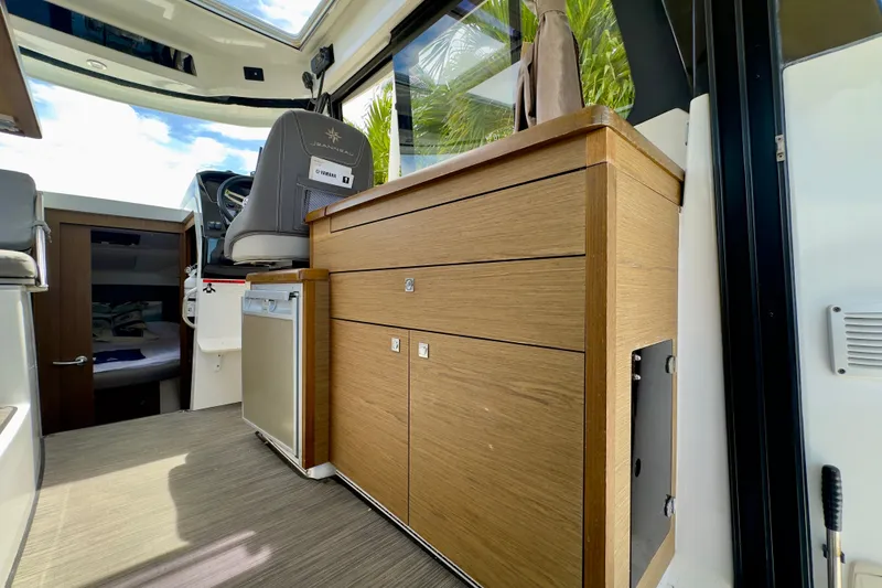 Slide: The Image of Interior of 2018 Jeanneau NC 895 boat with wooden cabinetry and seating. - 20