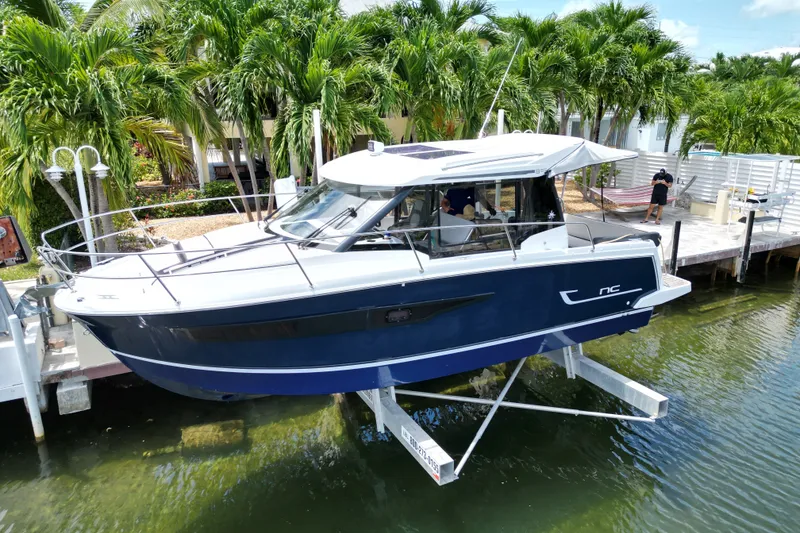 Slide: The Image of 2018 Jeanneau NC 895 boat docked near tropical palm trees. - 13