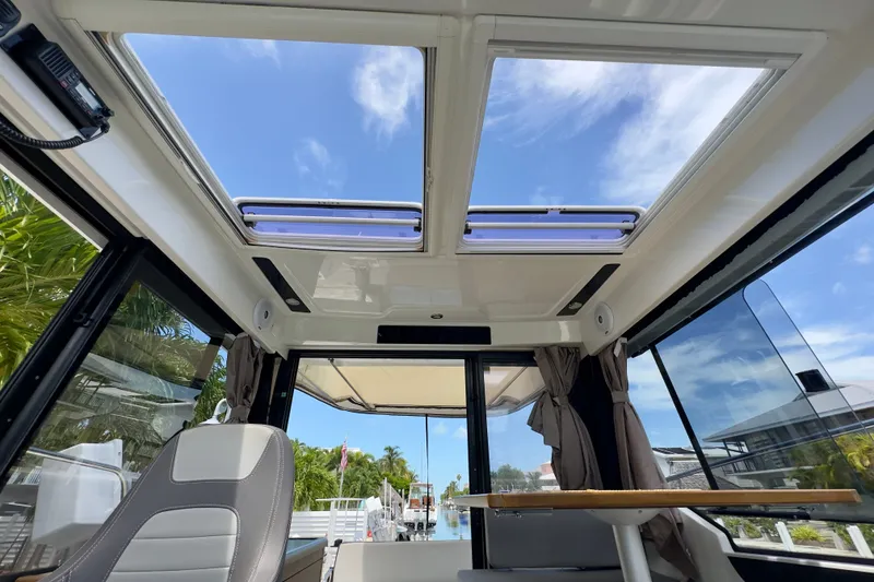 Slide: The Image of Interior view of 2018 Jeanneau NC 895 boat with open sunroof and seating area. - 33