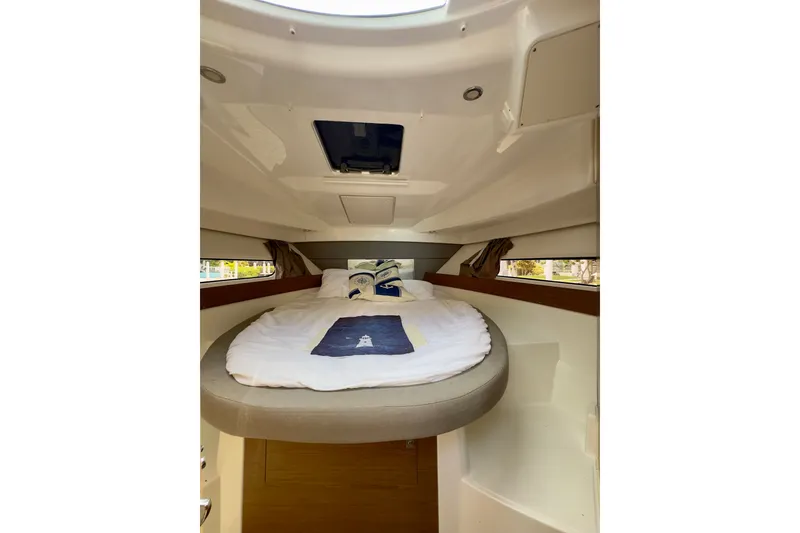 Slide: The Image of Cozy cabin interior of 2018 Jeanneau NC 895 boat with round bed and porthole. - 27