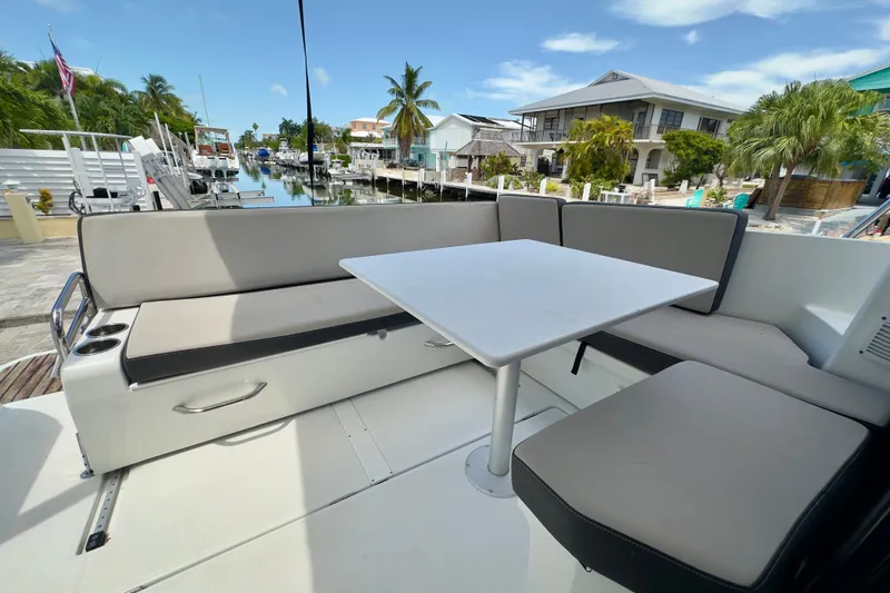 Slide: The Image of Outdoor seating area on 2018 Jeanneau NC 895 boat, featuring cushioned benches and a table. - 46